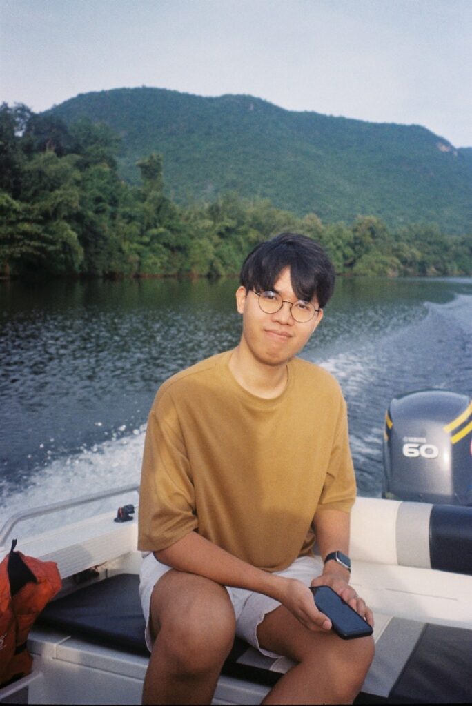 Sirakorn in yellow t-shirt, on a boat.